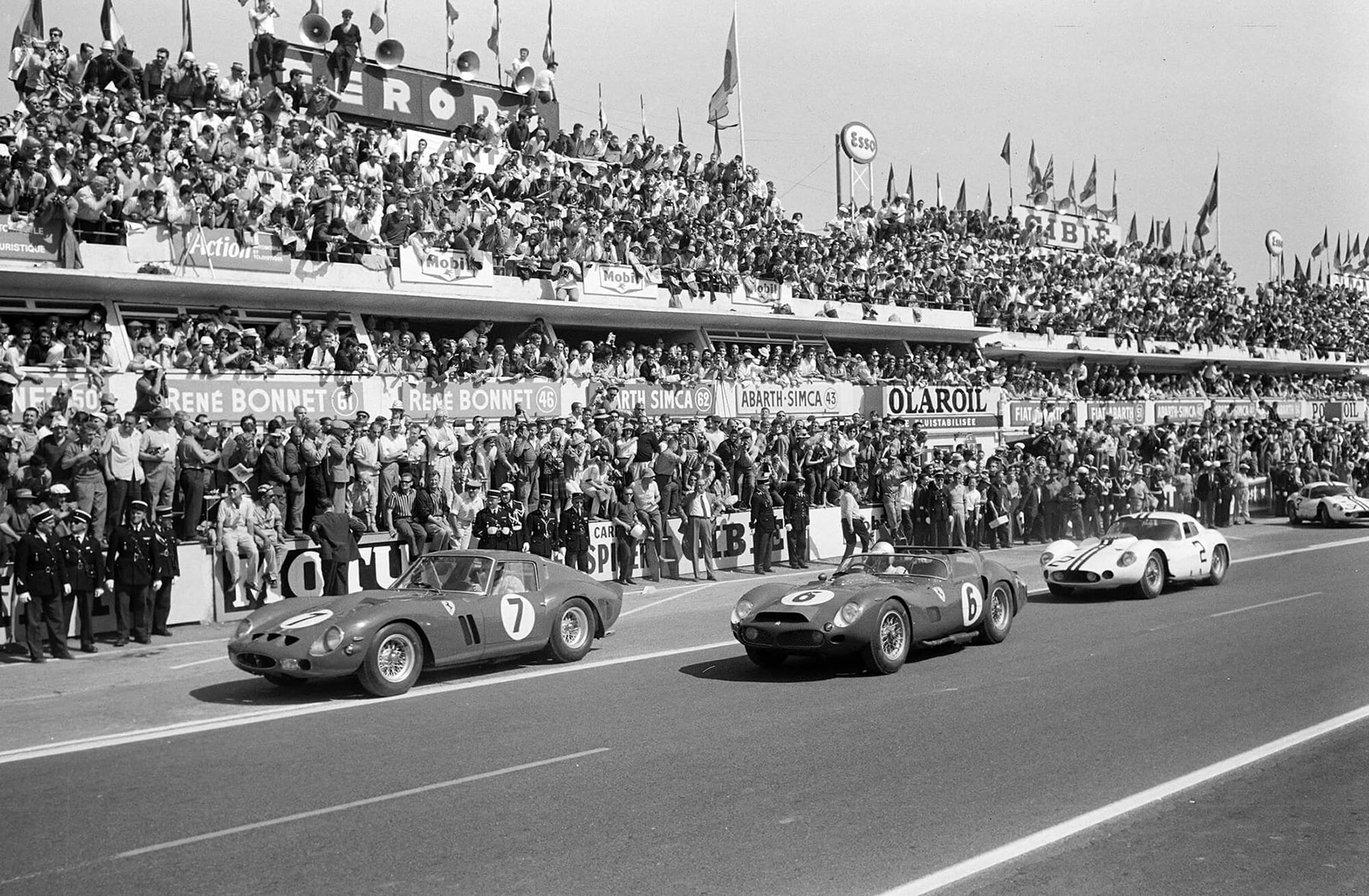 Mike Parkes and Lorenzo Bandini’s Ferrari (#7) leads Olivier Gendebien and Phil Hill’s Ferrari (#6) followed by Bruce McLaren and Walt Hansgen’s Maserati (#2) at the start during the 24 Hours of Le Mans at Circuit de la Sarthe on 24 June 1962.